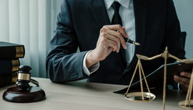 Lawyer in a suit at a desk with a gavel, law books and scales of justice, representing law firm AI visibility checks