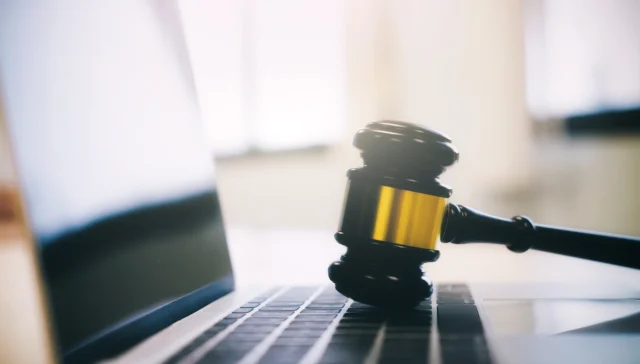 Judge's gavel resting on a laptop keyboard, representing law firm websites and AI recommendations