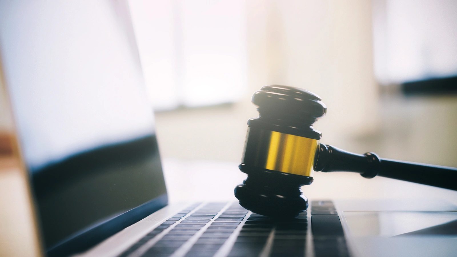 Judge's gavel resting on a laptop keyboard, representing law firm websites and AI recommendations